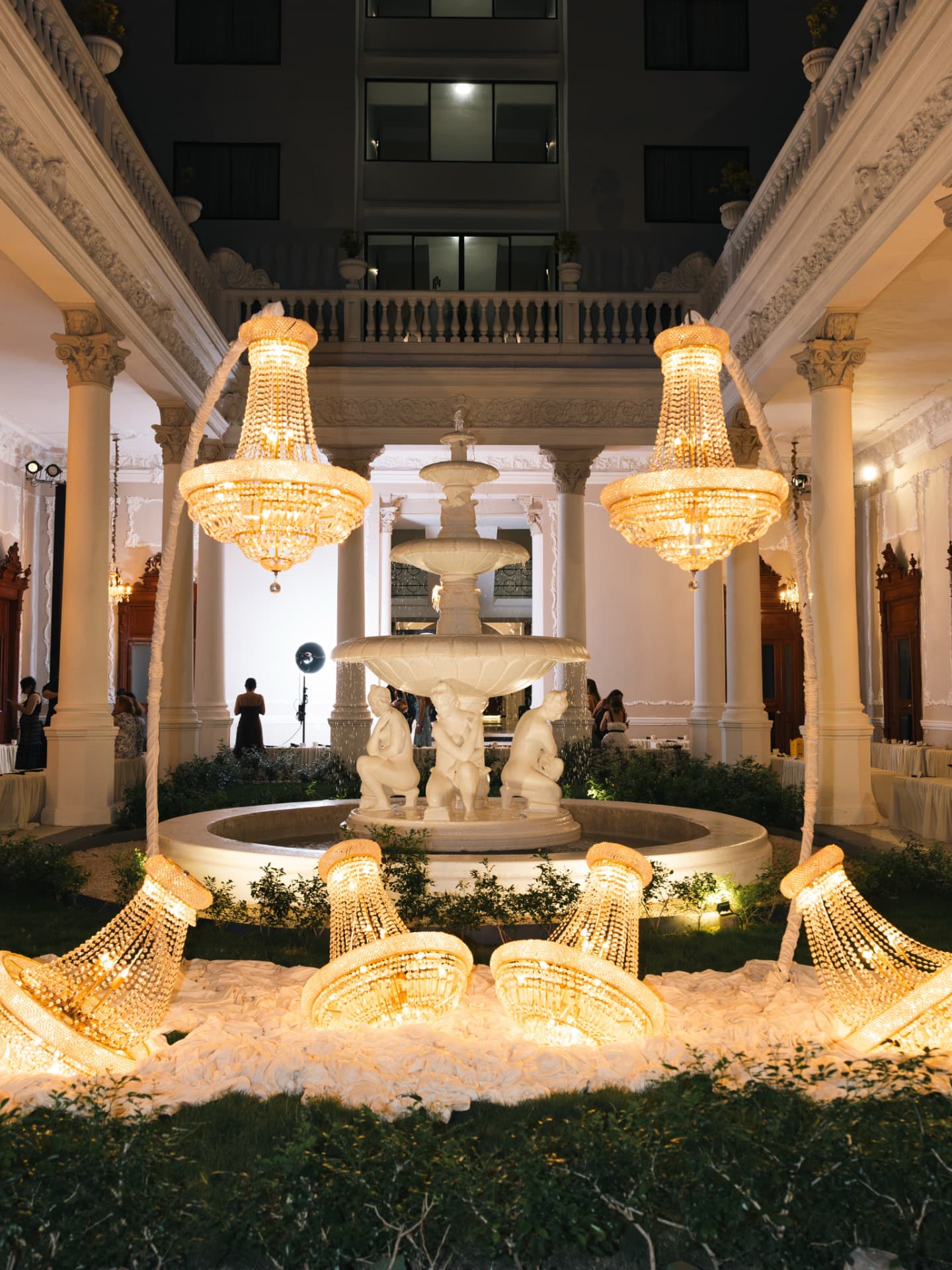 Fuente y candelabros en el patio nocturno